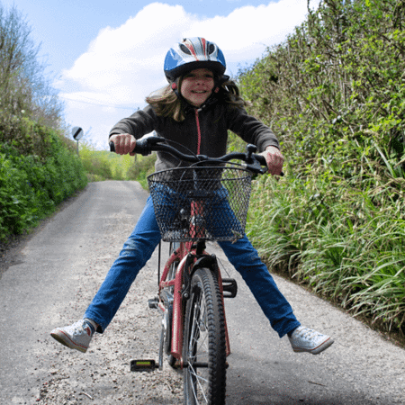 Fostering girl riding bike in the countryside